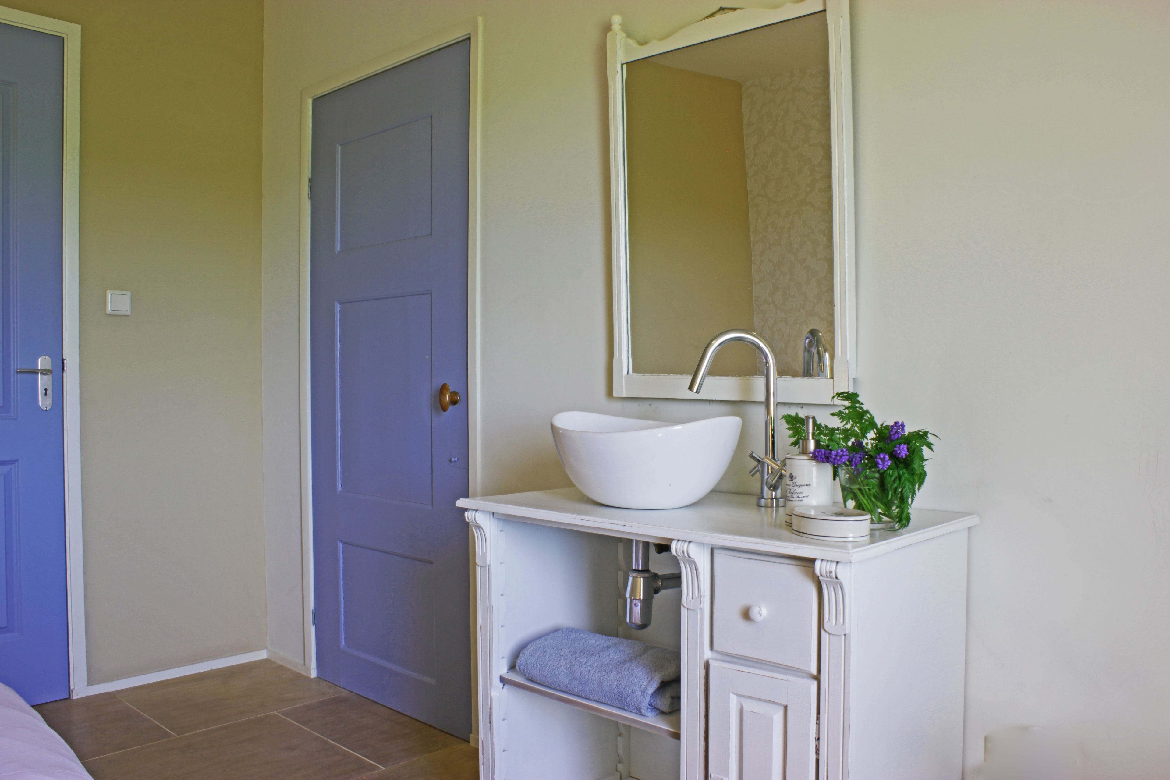 A bathroom with a white sink, mirror, and a towel rack.