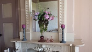 A bathroom vanity with a mirror, a vase of flowers, and two candles. - B&B en camping Welgelegen (Workum)
