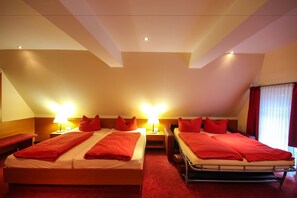 Habitación de hotel con dos camas, ropa de cama roja y alfombra roja.