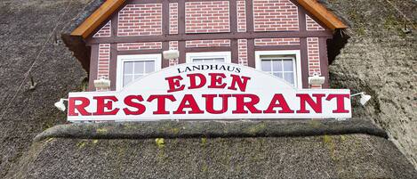 A traditional building with a thatched roof and a sign reading "EDEN RESTAURANT".