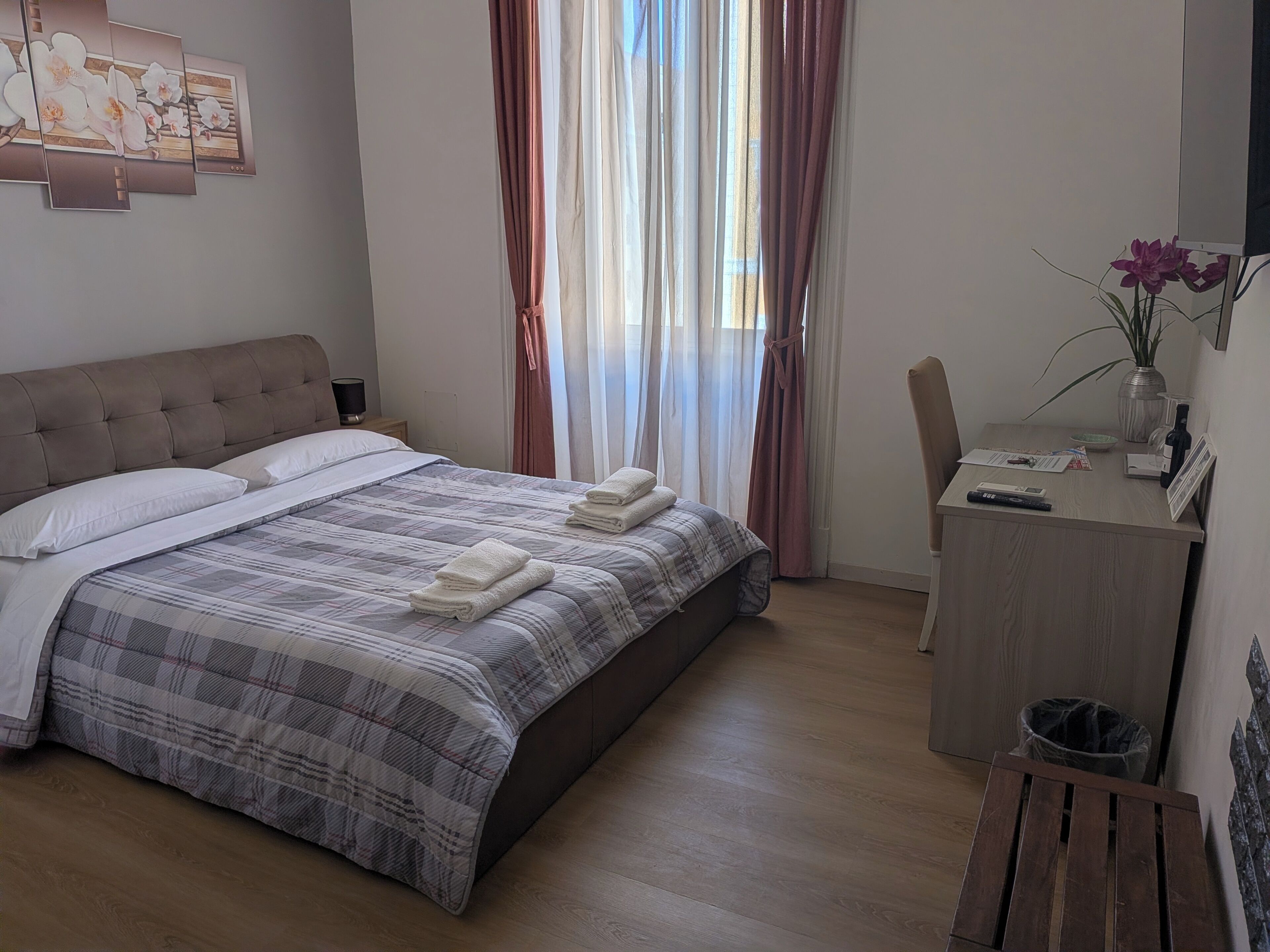 A neatly arranged bedroom with a bed, a desk, and a chair.