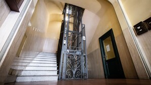 A staircase with a decorative metal gate leading to a room. - El Dorado Vatican (Rome)