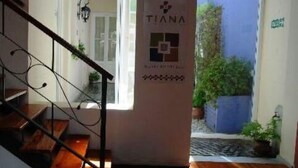 Una escalera conduce a una plataforma con un cartel que dice "TIANA" y un logotipo.