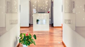 Un moderno hall de hotel con vigas de madera en el techo, un mostrador de recepción y paredes de vidrio.