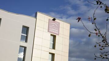 A modern building with a sign for Hotel Clermont-Estaing.