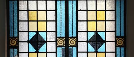 Una ventana de vitral con diseños geométricos y elementos decorativos.