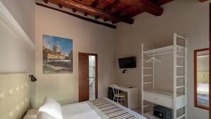 Una camera da letto con un letto, una scrivania, una televisione e un armadio.