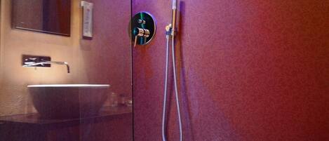 Ein modernes Badezimmer mit einer Duschkabine, einem Waschbecken und einem Spiegel.