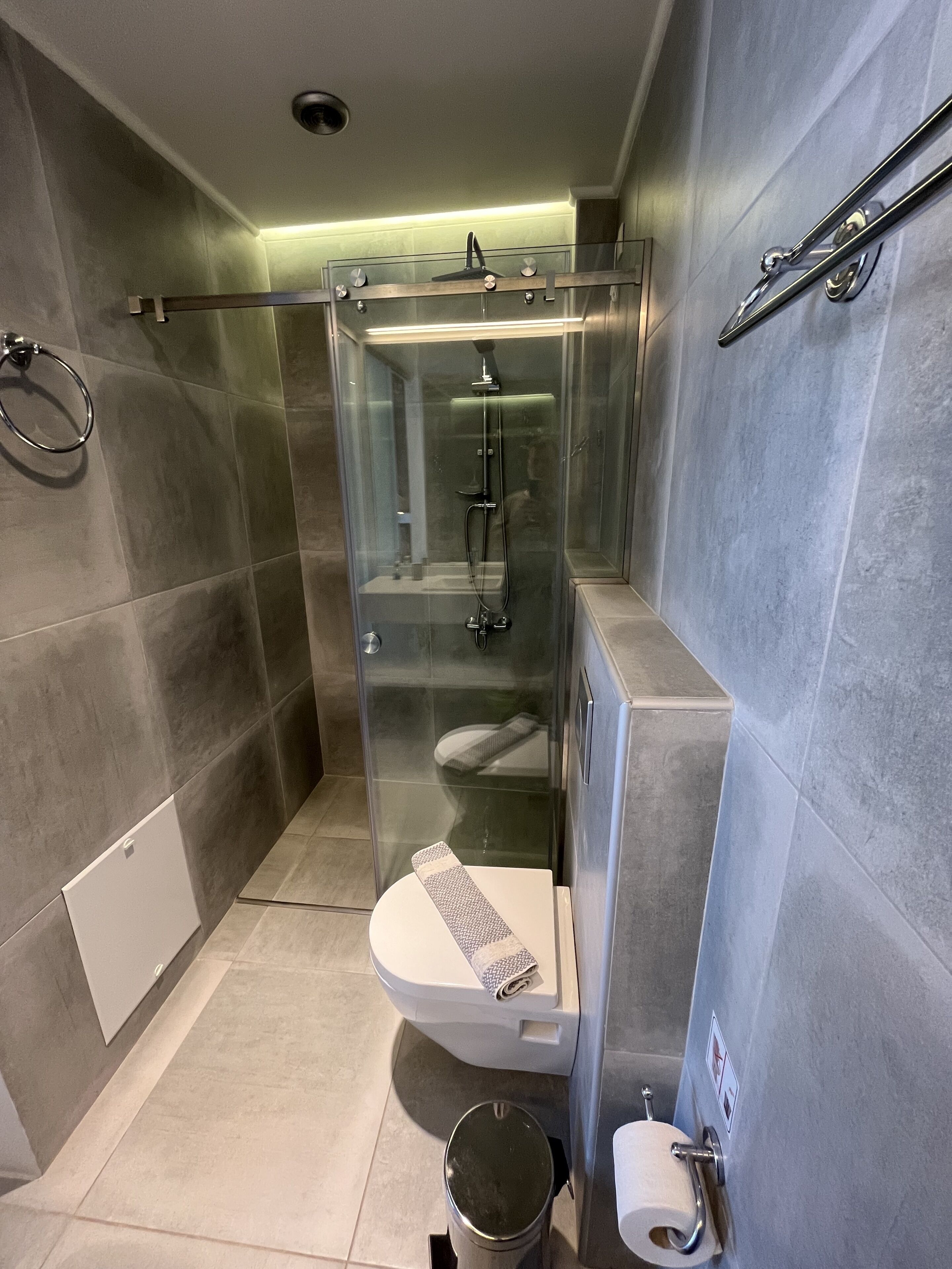 Une salle de bain moderne dotée d’une douche à parois de verre, de toilettes et d’un bidet.