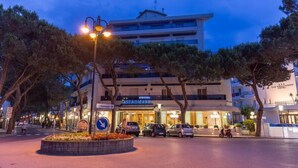 A hotel with a modern facade, a central entrance, and a parking area. - Astromare (Jesolo)