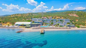 Un hôtel situé sur la côte, composé de plusieurs bâtiments, avec une plage et une jetée.