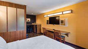 A hotel room with a bed, a desk with a chair, a TV, and a small kitchenette. - SureStay Plus Hotel by Best Western Keyser (Keyser)