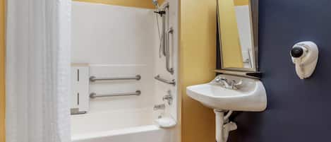 Een badkamer met een bad, een wastafel, een spiegel, een douche en een beveiligingscamera.
