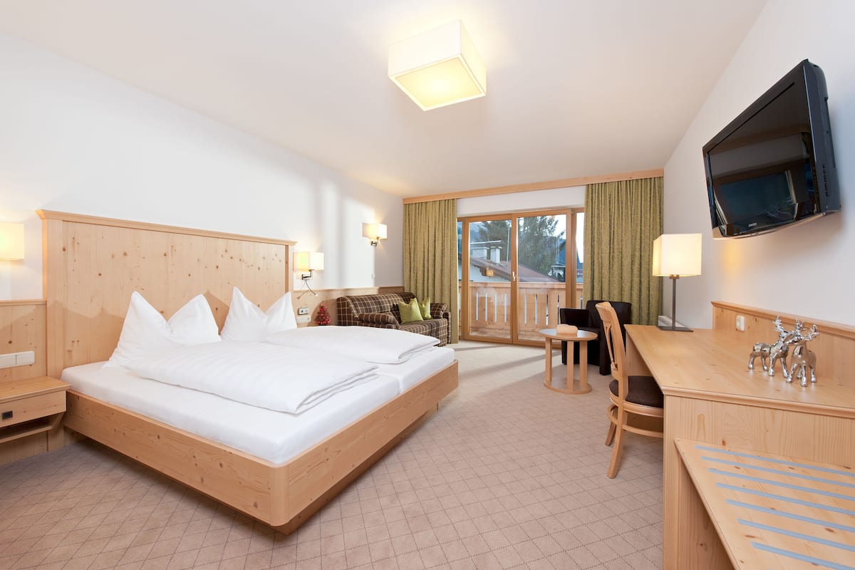 Une chambre d’hôtel avec un grand lit, un bureau, une chaise, une télévision et une vue sur l’extérieur.