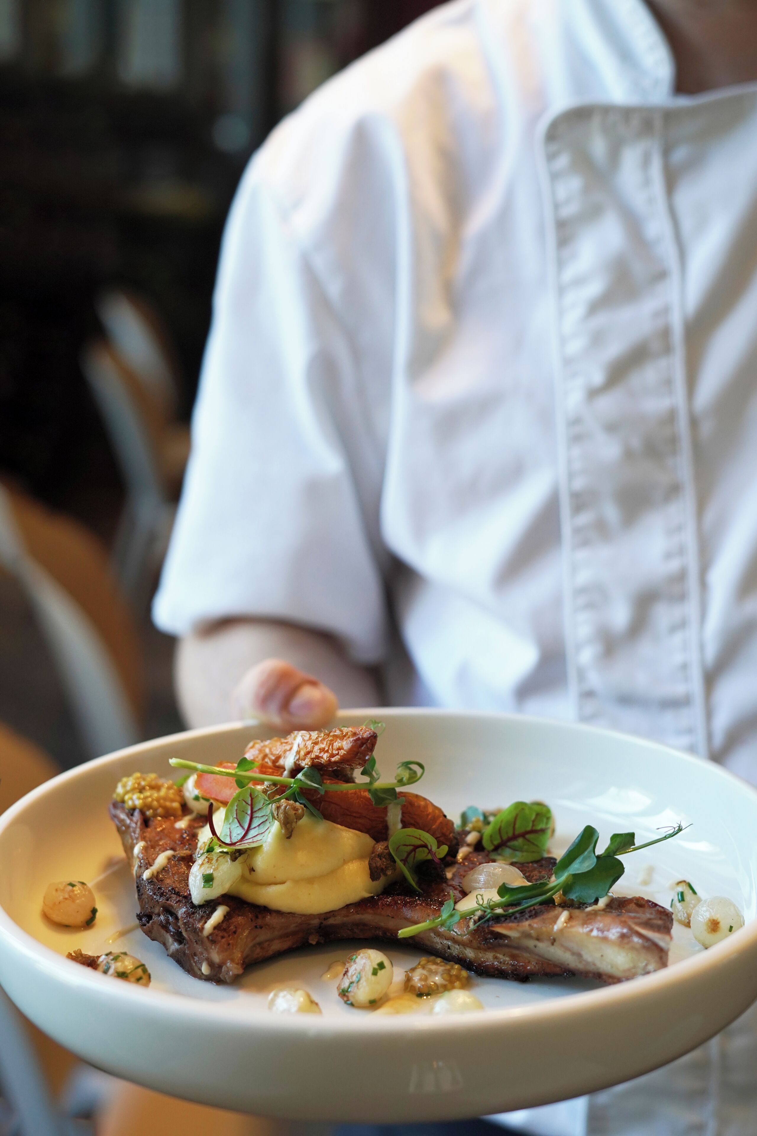 Un chef sostiene un plato de comida.