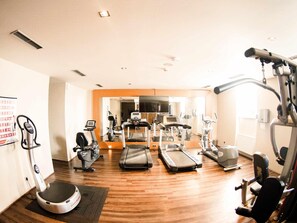 A gym with treadmills, elliptical machines, and a stationary bike.