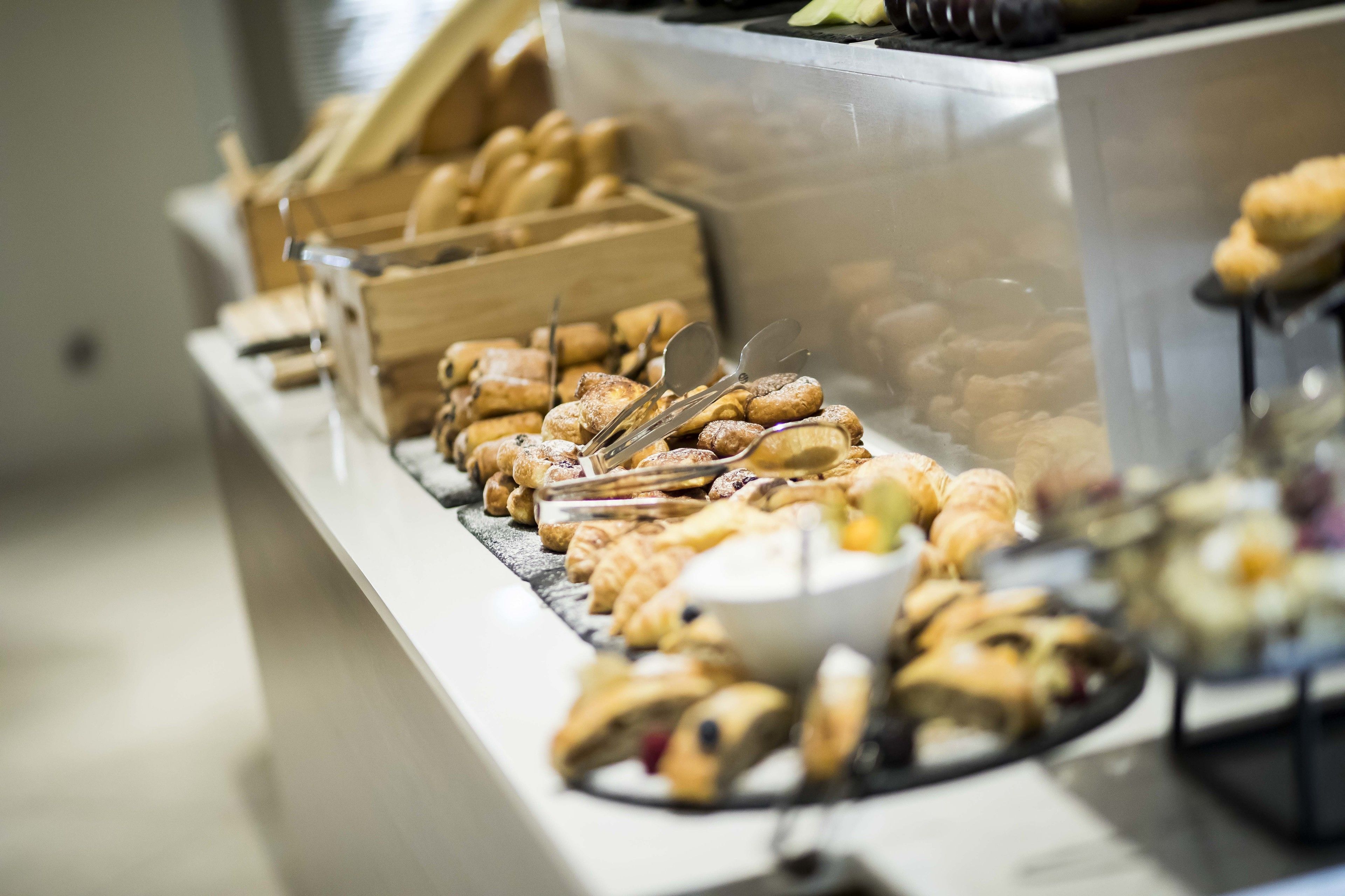 Un bufé con diversos pasteles y productos de panadería.