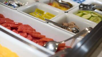 A buffet with various food items in separate containers.