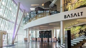 A modern interior with a glass facade, a staircase, and a reception desk labeled "BASALT". - AC Hotel by Marriott Bella Sky Copenhagen (Copenhagen)