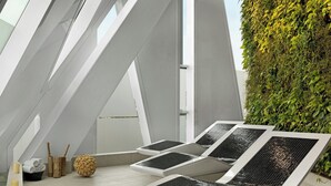 A modern outdoor lounge area with geometric white structures, a green vertical garden, and a spherical decorative element. - AC Hotel by Marriott Bella Sky Copenhagen (Copenhagen)
