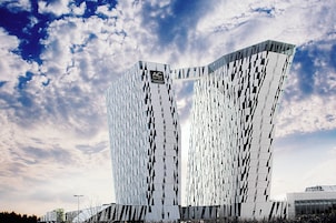 Un hotel moderno con una fachada geométrica distintiva y un logotipo destacado en la parte superior.