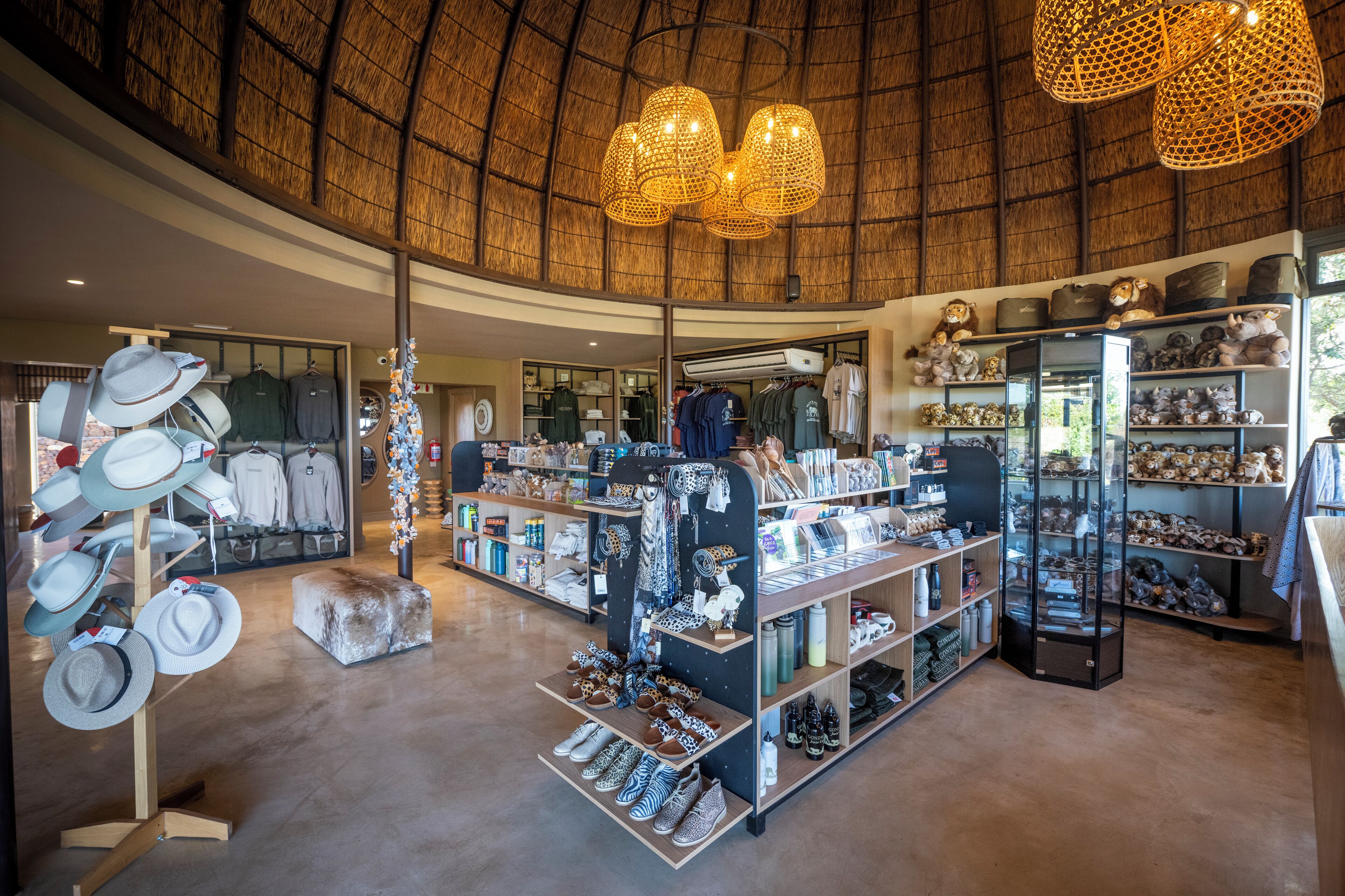 Una boutique espaciosa con techo curvo que exhibe sombreros, zapatos y diversos accesorios.