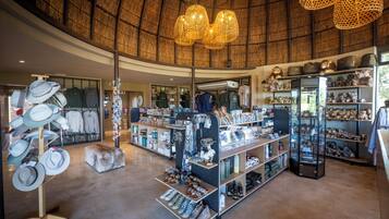 Una boutique espaciosa con techo curvo que exhibe sombreros, zapatos y diversos accesorios.