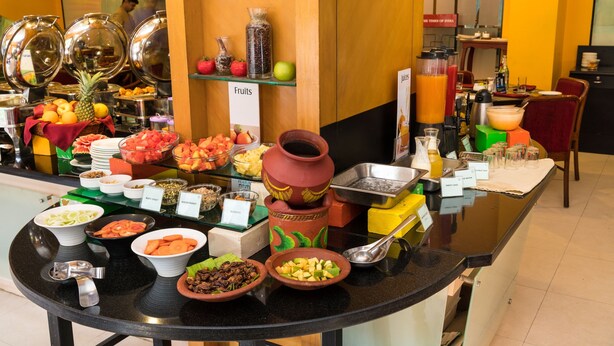 A buffet with various food items and a sign labeled "Fruits".