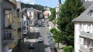 Une vue de rue avec des bâtiments, des voitures et des arbres.