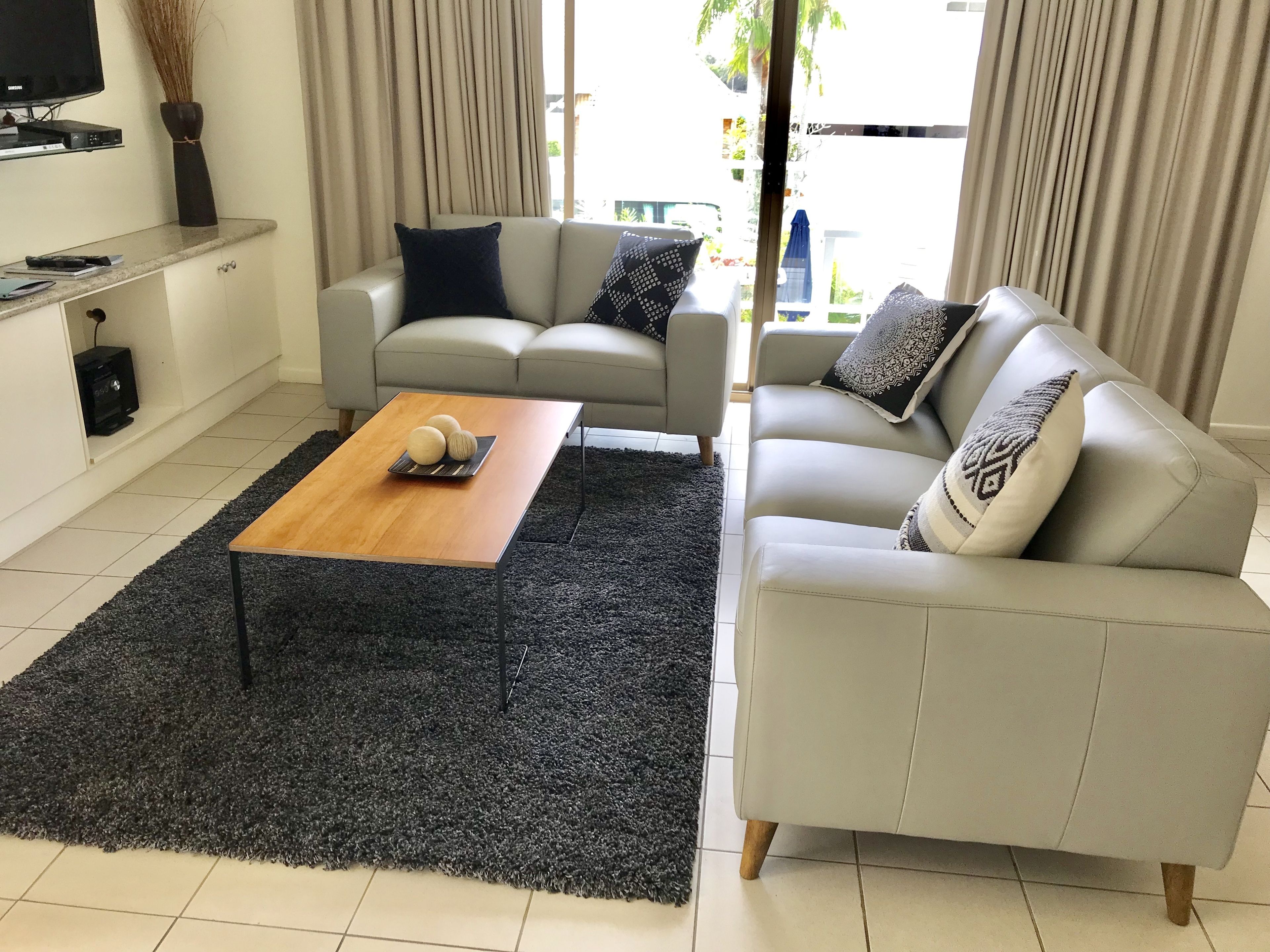 Una sala de estar moderna con un sofá, una mesa de centro y un televisor.