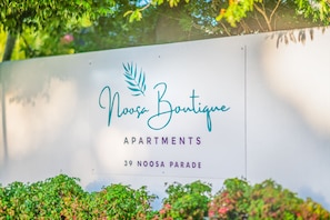A sign for Noosa Boutique Apartments at 39 Noosa Parade.