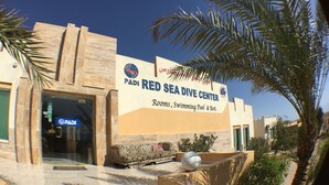 The exterior of the Red Sea Dive Center with a sign indicating rooms, swimming pool, and rest areas.