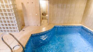 Relax by the pool, surrounded by a spacious area with a shower and bathroom nearby.