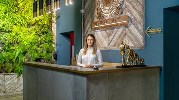 Un mostrador de recepción con un letrero que indica 'Tulip Residence' y 'Ascensor para Conferencias'.