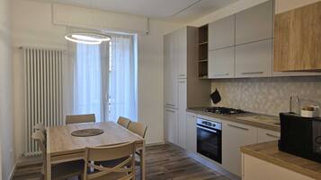 Una cocina moderna con una mesa, sillas, estufa y armarios.