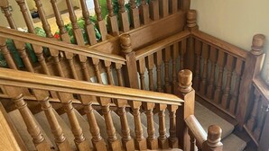 A wooden staircase with a handrail and balusters.