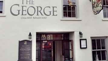 Een gebouw met het bord "The George" en een plaquette waarop staat dat het in 2010 herbouwd is.