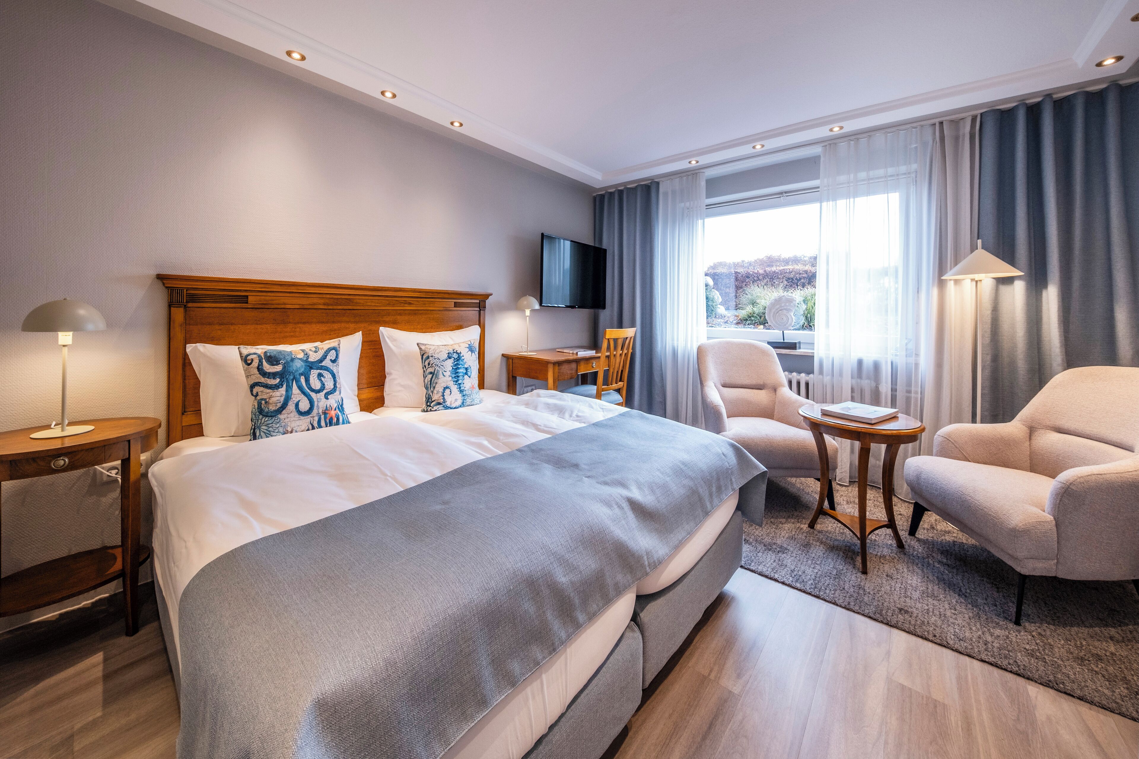 Una camera d'albergo con un letto grande, una scrivania, una sedia e una televisione.