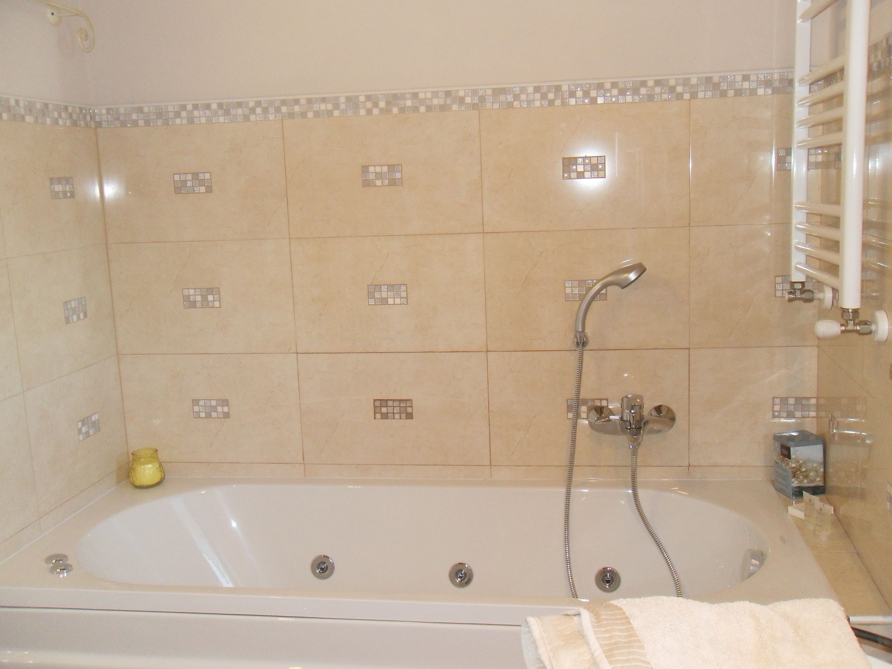 A bathroom with a bathtub, a shower, and a towel rack.