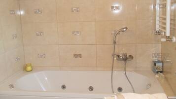 A bathroom with a bathtub, a shower, and a towel rack.