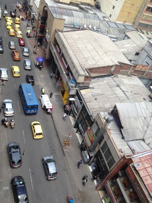 Una calle urbana concurrida con diversos vehículos, como taxis, autobuses y automóviles.
