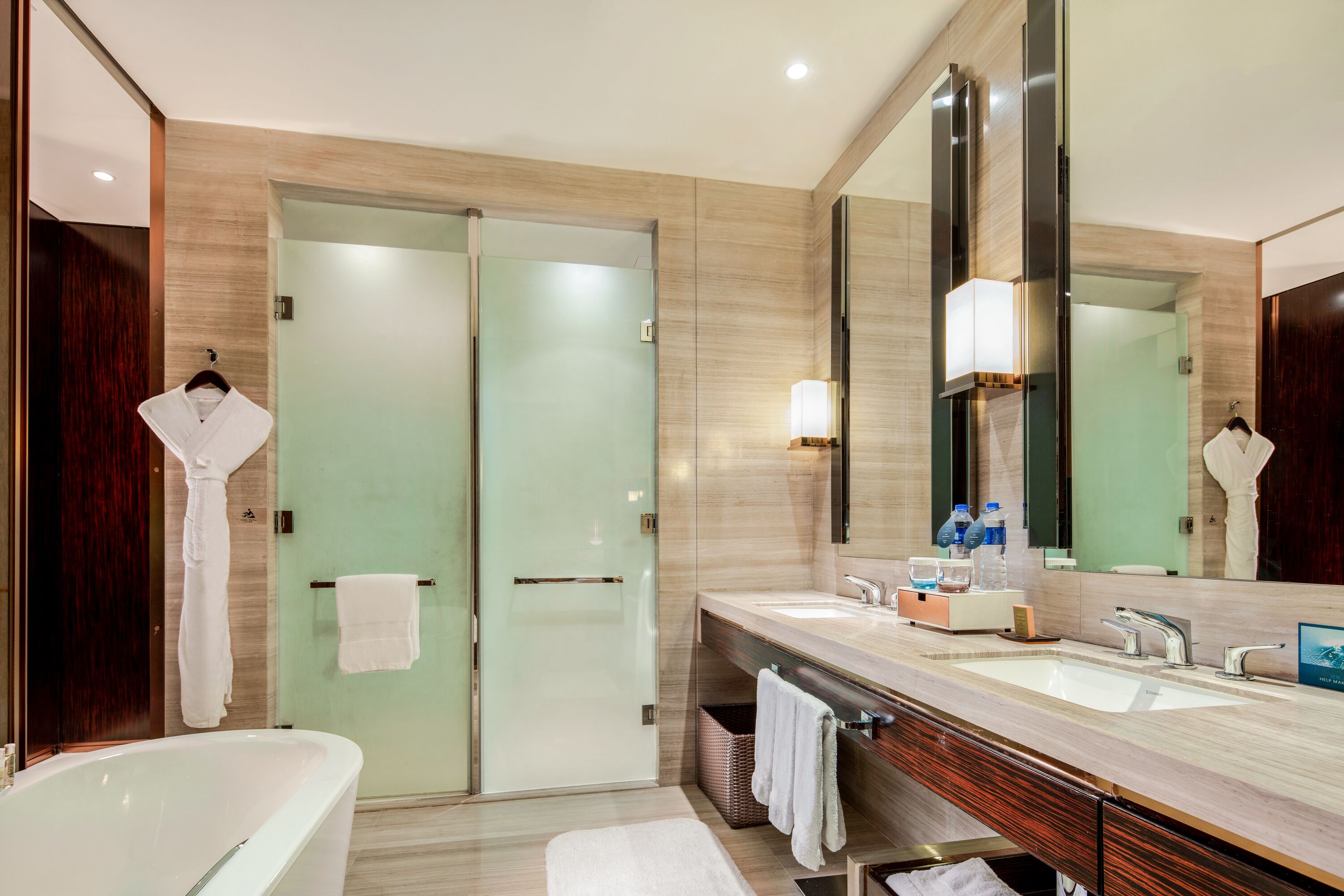 A modern bathroom with a glass-enclosed shower, a freestanding bathtub, and a large mirror.