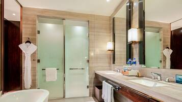 A modern bathroom with a glass-enclosed shower, a freestanding bathtub, and a large mirror.