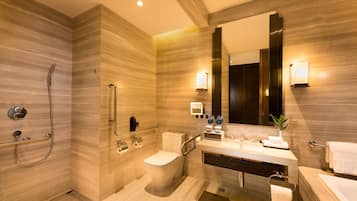A modern bathroom with a shower, toilet, sink, and large mirror.