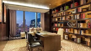 A modern library with a large bookshelf, a desk, and a view of the cityscape. - Hilton Shenzhen Futian (Shenzhen)