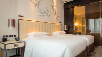 A hotel room with a large bed, bedside tables, a phone, and a wall-mounted artwork.