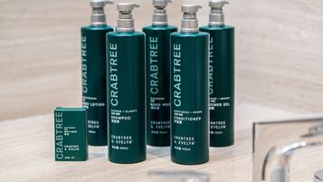 En uppsättning gröna flaskor märkta med texten ”CRABTREE” som innehåller olika hudvårdsprodukter, till exempel schampo, balsam och lotion.