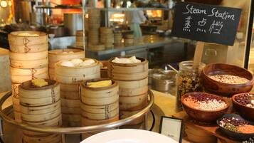 A display of steamed buns and various ingredients at a food station.