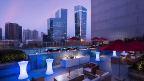 A rooftop bar with seating, a pool, and city skyline views. - Hilton Shenzhen Futian (Shenzhen)