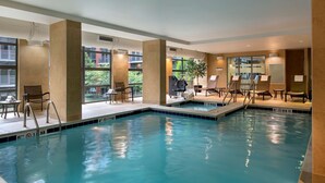 An indoor swimming pool with clear water, surrounded by lounge chairs and a small hot tub area. - Hilton Garden Inn Washington DC/U.S. Capitol (Washington)